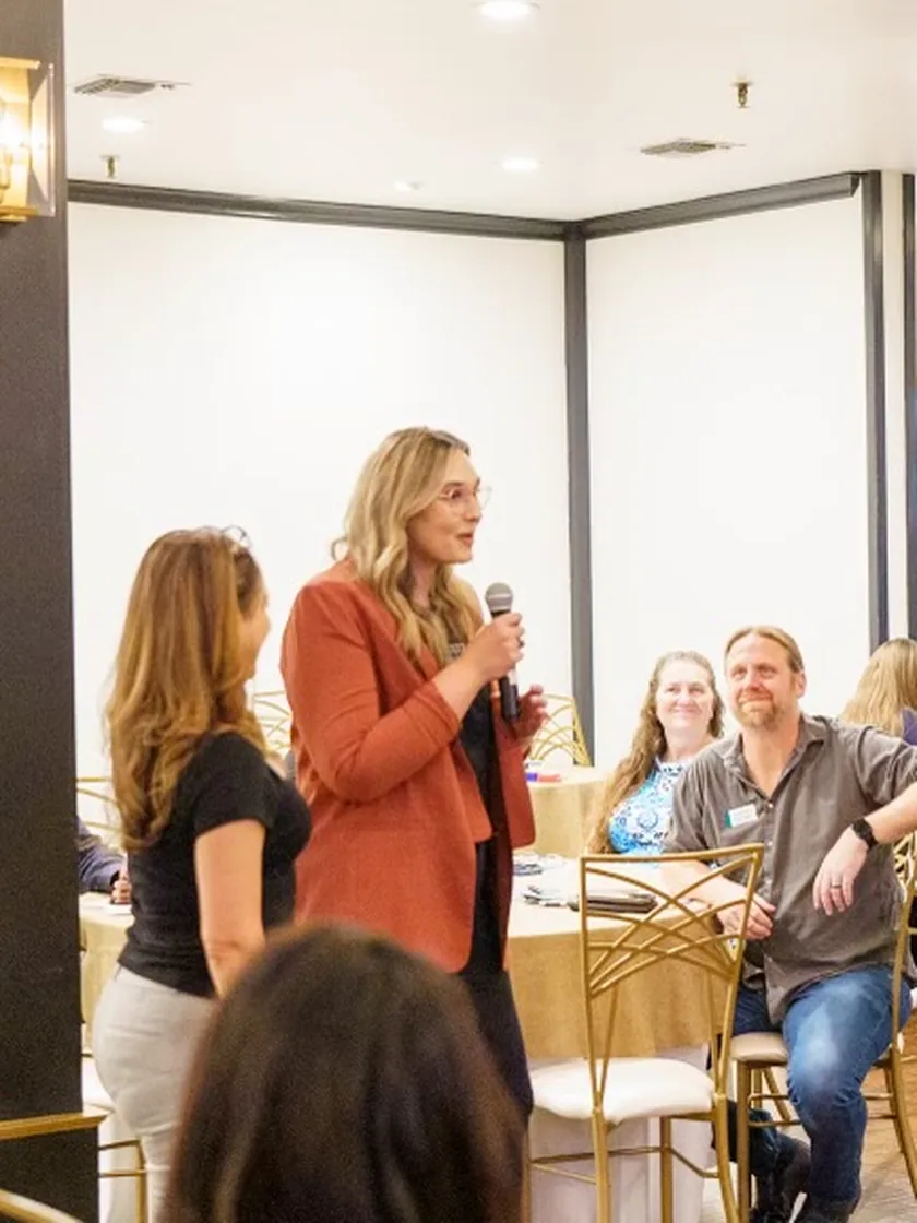 A PathBuilders founder taking questions with a microphone at an industry event.
